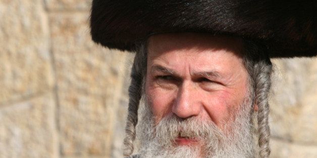 [UNVERIFIED CONTENT] An Ultra-Orthodox Jewish man, with long Payots, beard and a Shtreimel (special hat) looking with his eyes narrowed. Te photo was taken at the Western Wall (Wailing Wall) of Jerusalem, during the Jewish feast Passover.