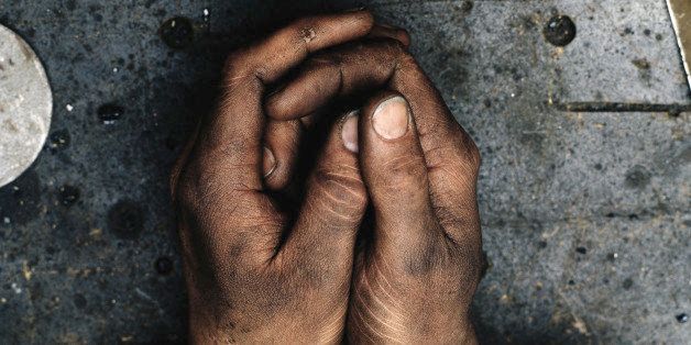 Man clasping hands covered in dirt, close-up of hands, overhead view