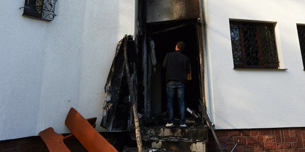 Police and prosecution officers inspect the site of the Mosque fire in Gdansk, Poland, on October 16, 2013. A fire broke out on Wednesday morning at the entrance to the mosque. A mosque in Poland was hit by arson in the small hours of Wednesday as some Muslims here celebrating the Eid al-Adha holiday refrained from halal animal slaughter amid and a nationwide ban. AFP PHOTO / PAP/ADAM WARZAWA / POLAND OUT EASTNEWS OUT (Photo credit should read Adam Warzawa/AFP/Getty Images)