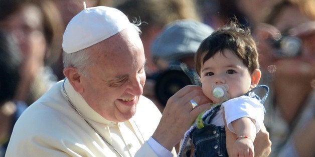 Pope Francis blesses a child as he arrives for his general audience at St Peter's square on October 16, 2013 at the Vatican. AFP PHOTO / ALBERTO PIZZOLI (Photo credit should read ALBERTO PIZZOLI/AFP/Getty Images)