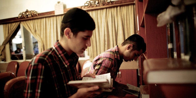 Iranian Jewish men read the holy Torah at a synagogue in downtown Tehran on September 24, 2013. Present for more than 2,500 y