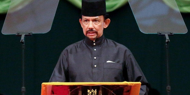 Brunei Sultan Hassanal Bolkiah delivers his speech during the official opening of the Majlis Ilmu 2013 in Bandar Seri Begawan on October 22, 2013. The Sultan of Brunei on October 22, announced the phased introduction of tough Islamic punishments including death by stoning for crimes such as adultery, in the monarchy's latest step towards conservatism. AFP PHOTO / DEAN KASSIM (Photo credit should read DEAN KASSIM/AFP/Getty Images)