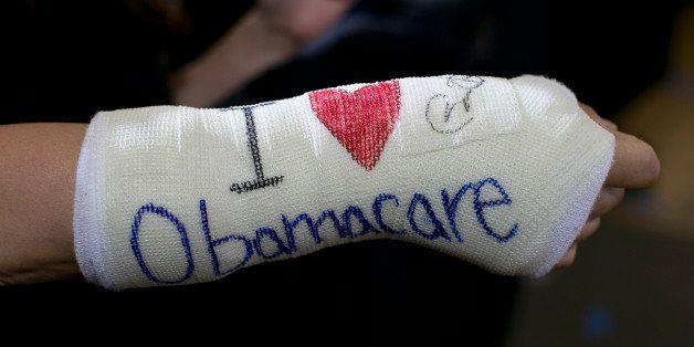 BOSTON - OCTOBER 30: Cathey Park, of Cambridge, displayed a cast on her broken wrist with 'I (heart) Obamacare' written on it. When U.S. President Barack Obama finished his speech, he shook hands with the crowd and signed her cast, next to the heart. President Obama spoke at Faneuil Hall to bolster support for his national health care law in Boston, Mass. on Wednesday, October 30, 2013. (Photo by Yoon S. Byun/The Boston Globe via Getty Images)