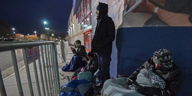 Gamer Josh Aaront (L rear) waits first in line at the Fairfax, Virginia, Best Buy, with about 20 other sidewalk campers, for the midnight sale of the new Microsoft Xbox One, November 21, 2013, in Fairfax, Virginia. He arrived at 9pm Wednesday evening and was also there last week for the midnight sale of the Playstation 4 and has plans to return for Black Friday. AFP PHOTO/Paul J. Richards (Photo credit should read PAUL J. RICHARDS/AFP/Getty Images)