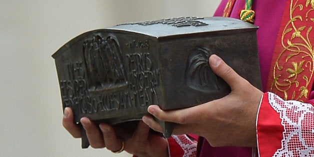 Italian archbishop Rino Fisichella holds the bone fragments said by some to belong to the first pope, St. Peter during a ceremony of Solemnity of Our Lord Jesus Christ the King at St Peter's square on November 24, 2013 at the Vatican. AFP PHOTO / VINCENZO PINTO (Photo credit should read VINCENZO PINTO/AFP/Getty Images)