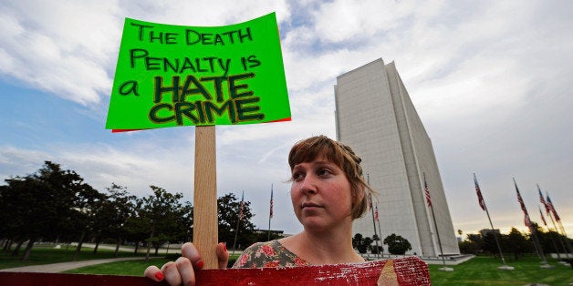 LOS ANGELES, CA - SEPTEMBER 28: Anti-death penalty protester Katie Wilde holds a placard during a rally and a march in front of the Federal Building on September 28, 2010 in the Westwood section of Los Angeles, California. U.S. District Court Judge Jeremy Fogel blocked the execution that was scheduled at 9:00 pm Thursday. Albert Greenwood was sentenced to death for abducting and raping a 15-year-old schoolgirl in 1980. (Photo by Kevork Djansezian/Getty Images)