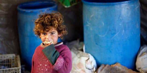 A young Palestinian Bedouin girl eats a peice of bread at their encampment in Khan Yunis in the southern Gaza Strip on Decemb