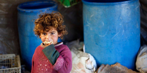 A young Palestinian Bedouin girl eats a peice of bread at their encampment in Khan Yunis in the southern Gaza Strip on December 17, 2013. A fierce winter storm shut down much of the Middle East last week leaving people to clear up following flood waters and heavy snow in some countries. AFP PHOTO /SAID KHATIB (Photo credit should read SAID KHATIB/AFP/Getty Images)