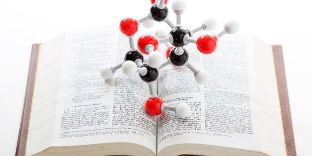 Concept for science versus religion, or evolution versus creationism. A molecular model on a bible.