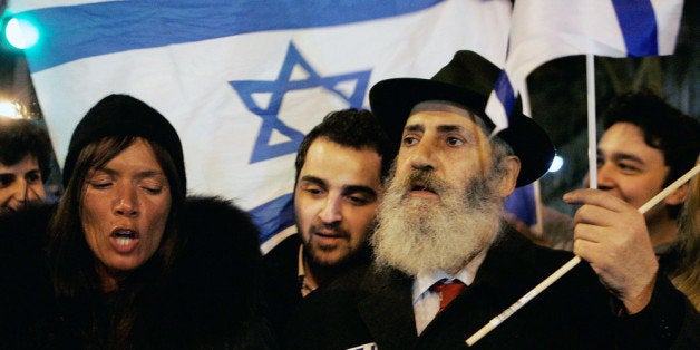 PARIS, FRANCE - MARCH 19: Members of the Jewish community of Paris demonstrates s on Place de la Bastille as they attend a silent march to pay tribute to the victims of the Toulouse school shooting, during a night time vigil on March 19, 2012 in Paris, France. Four people, including three children, have been killed and others injured after a gunman opened fire outside a Jewish school in Toulouse as parents dropped their children off for morning classes. (Photo by Franck Prevel/Getty Images)