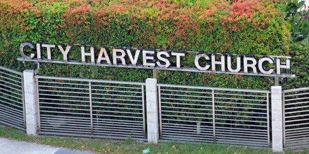 A cyclist rides past the City Harvest Church in Singapore on June 26, 2012. The founder of one of Singapore's richest churches, the City Harvest Church, was arrested on June 26 on allegations of misusing at least 18 million USD in donations from his congregation of more than 30,000, police said. AFP PHOTO / ROSLAN RAHMAN (Photo credit should read ROSLAN RAHMAN/AFP/GettyImages)