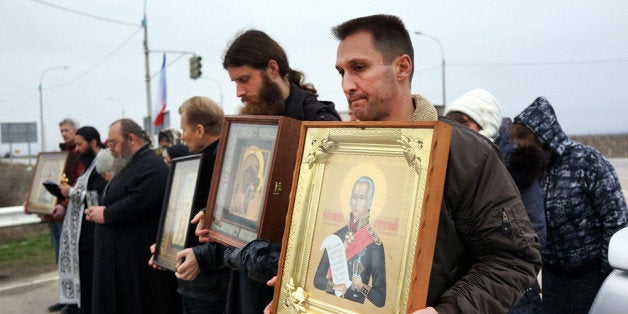 BELBEK, UKRAINE - MARCH 07: Members of an Orthodox church participate in a prayer vigil outside of a Russian military checkpoint near a Ukrainian Air-force base that has been seized by the Russians on March 7, 2014 in Belbek, Ukraine. As the standoff between the Russian military and Ukrainian forces continues in Ukraine's Crimean peninsula, world leaders are pushing for a diplomatic solution to the escalating situation. Crimean citizens will vote in a referendum on 16 March on whether to become part of the Russian federation. (Photo by Spencer Platt/Getty Images)