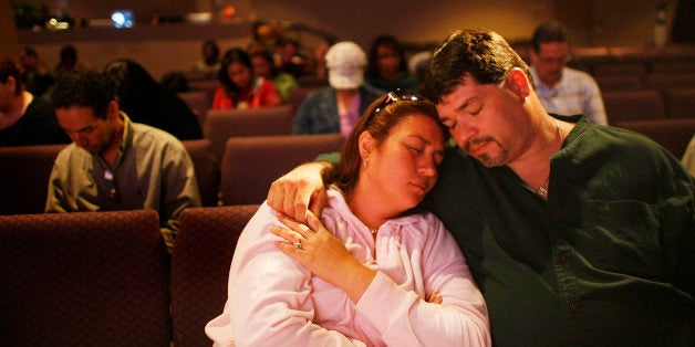 KENDALL, FL - MARCH 07: Priscilla Mendez and Tony Mendez pray together as Kevin Cross delivers a sermon about faith-based financial management to a congregation at the Miami Vineyard Community Church on March 7, 2009 in Kendall, Florida. Cross preaches to people about the biblical principles of money management with his idea of steps that should be taken for handling finances to glorify and honor God. With the economic hard times that have fallen upon many people, churches around the country are trying new programs such as Cross's Margin and Meaning events, to guide people out of their debt and get back on their feet financially. (Photo by Joe Raedle/Getty Images)