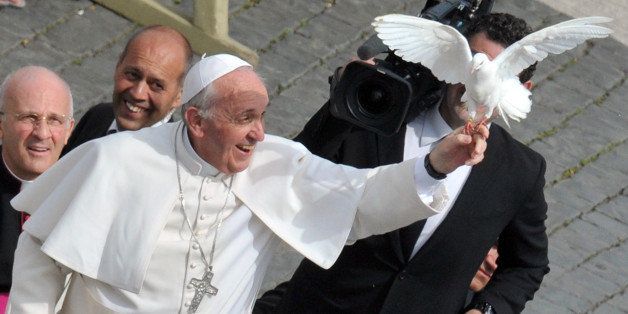 Pope Francis grabs a dove as he arrives for his weekly general audience in St Peter's Square on May 15, 2013 at the Vatican. AFP PHOTO / TIZIANA FABI (Photo credit should read TIZIANA FABI/AFP/Getty Images)