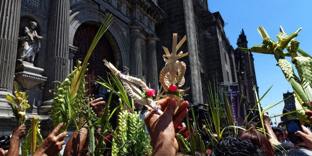 Catholics take part in the traditional Palm Sunday procession by the Cathedral in Mexico City on March 24, 2013. Palm Sunday marks the beginning of Holy Week, and commemorates Christ's triumphant entry into Jerusalem on the back of a donkey, welcomed by crowds waving palm branches, before his arrest, trial, crucifixion and resurrection. It is traditionally marked by a procession and special mass. AFP PHOTO/ Yuri CORTEZ (Photo credit should read YURI CORTEZ/AFP/Getty Images)