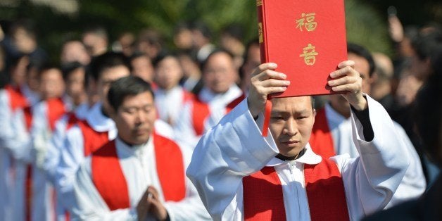 Clergy arrive for the funeral of the late head of the underground Catholic Church in Shanghai, Bishop Joseph Fan Zhongliang, as he lies in a funeral home in Shanghai on March 22, 2014. Thousands of mourners packed the funeral home to bid farewell to the 'underground' Catholic Bishop whose faith, they said, led him to endure decades of suffering at the hands of China's ruling Communist Party. AFP PHOTO/Peter PARKS (Photo credit should read PETER PARKS/AFP/Getty Images)