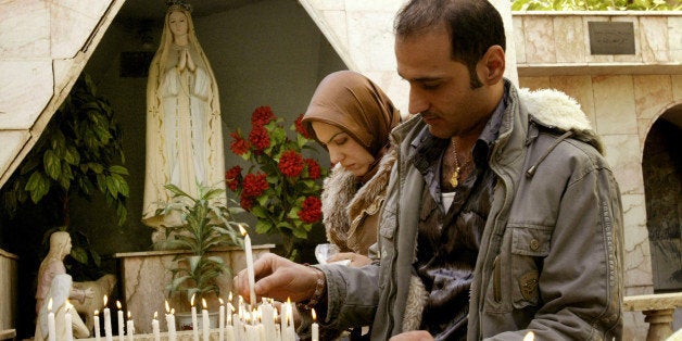 BAGHDAD, IRAQ, DECEMBER 25: Iraqi Christians light candles after attending Christmas mass at the Virgin Mary church on December 25, 2008 in Baghdad, Iraq. Iraqi Christians celebrated Christmas as security continues to improve in the Iraqi capital of Baghdad. Although there has been some reduction in violence in Iraq, the US Commission on International Religious Freedom expressed its concern about 'severe abuses of religious freedom' of non-Muslim Iraqis which include ChaldoAssyrian Christians, other Christians, Sabean Mandaeans, and Yazidis. (Photo by Wathiq Khuzaie/Getty Images)