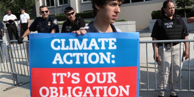 WASHINGTON, DC - AUGUST 12: An activist holds a sign as he participates in a sit-in and protest against the Keystone XL pipeline outside the U.S. State Department August 12, 2013 in Washington, DC. Activists from the Rainforest Action Network, CREDO and other groups expressed their opposition to the Keystone XL pipeline and urged 'to maintain pressure on the president to keep his promise to fight climate change by rejecting the Keystone XL pipeline.' (Photo by Alex Wong/Getty Images)