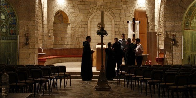 Priests and Israeli policemen inspect a Catholic church on May 26, 2014 after arsonists set fire to it at a contested site in