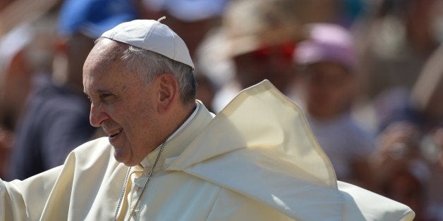 Pope Francis greets the crowd as he arrives for his general audience at St Peter's square on June 11, 2014 at the Vatican. AFP PHOTO / VINCENZO PINTO (Photo credit should read VINCENZO PINTO/AFP/Getty Images)