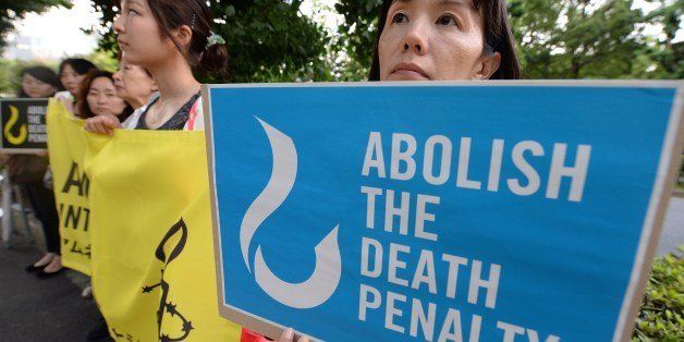 Members of civic groups hold banners denouncing the death penalty during a demonstration in front of the Justice Ministry in Tokyo on June 26, 2014. Japan carried out its first execution of the year on June 26 when it hanged a man for a triple murder, the ninth prisoner to be put to death since the conservative government of Shinzo Abe took power in 2012. AFP PHOTO/Toru YAMANAKA (Photo credit should read TORU YAMANAKA/AFP/Getty Images)