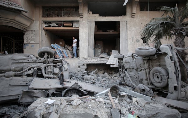 A Palestinian man walks next to a destroyed house following an overnight Israeli missile strike in Gaza City Monday, July 14,