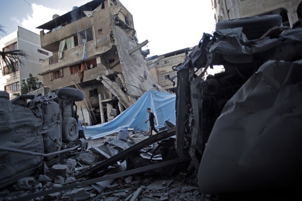 A Palestinian man walks next to a destroyed house following an overnight Israeli missile strike in Gaza City Monday, July 14,
