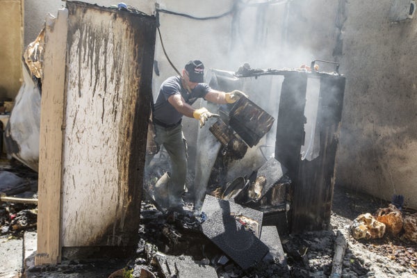 Israeli bomb disposal experts inspect the damage at a house following a rocket attack by Palestinian militants from the Gaza 
