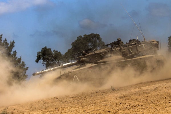 An Israeli Merkava tank rolls at an army deployment along the Israel's border with the Gaza Strip on July 14, 2014.