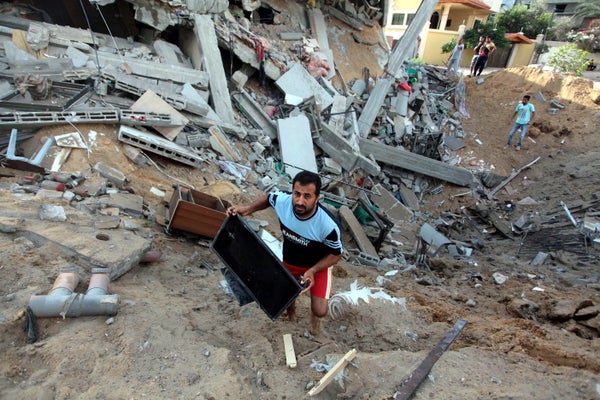 Palestinians inspect a house destroyed in air attacks staged by Israel army within the scope of 'Operation Protective Edge' i