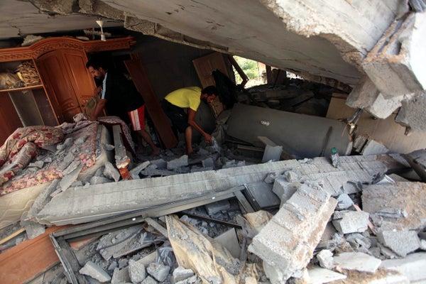 Palestinians inspect a house destroyed in air attacks staged by Israel army within the scope of 'Operation Protective Edge' i