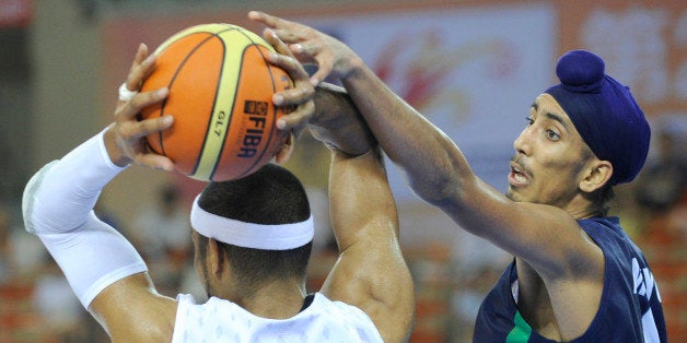 Moon Tae Jong of South Korea (L) passes a ball as Amjyot Singh of India (R) defends during their preliminary round match betw