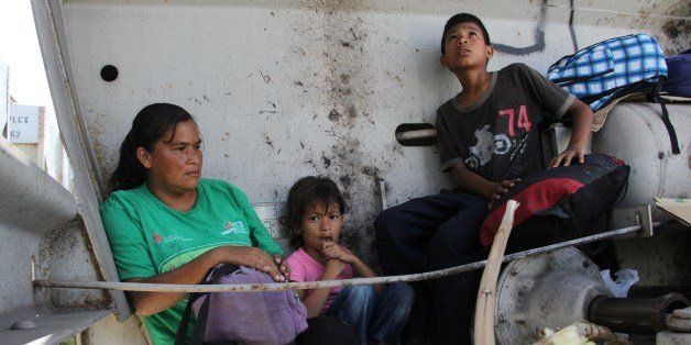 A Central American immigrant and her children sit inside the so-called La Bestia (The Beast) cargo train, in an attempt to reach the Mexico-US border, in Arriaga, Chiapas state, Mexico on July 16, 2014. AFP PHOTO/ELIZABETH RUIZ (Photo credit should read ELIZABETH RUIZ/AFP/Getty Images)