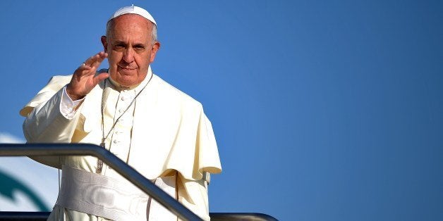 Pope Francis waves from the top of the stairs leading to the plane as he leaves to his trip to the Holy Land on May 24, 2014.