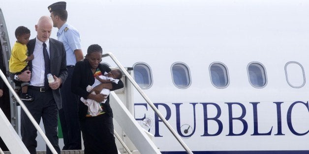 Sudanese Christian Meriam Yahia Ibrahim Ishag (R) is assisted by Italian Deputy Foreign Minister Lapo Pistelli (L) as she arrives with her children Maya and Martin, at the Ciampino airport in Rome on July 24, 2014. Meriam Yahia Ibrahim Ishag who was sentenced to death for renouncing Islam, then acquitted after intense international pressure on Khartoum, arrived today in Italy with her family en route to the United States. AFP PHOTO /STRINGER (Photo credit should read STR/AFP/Getty Images)