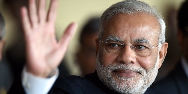 India's Prime Minister Narendra Modi waves while leaving the BRICS-UNASUR Summit at Itamaraty Palace in Brasilia, Brazil on J