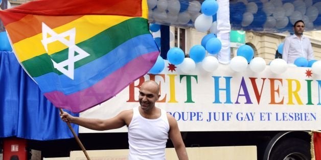 Members of the Jewish gay and lesbian association wave rainbow flags with the Star of David, during the lesbian, gay, bisexual and transgender (LGBT) visibility march, the Gay Pride, under the rain, on June 28, 2014 in Paris. AFP PHOTO / DOMINIQUE FAGET (Photo credit should read DOMINIQUE FAGET/AFP/Getty Images)