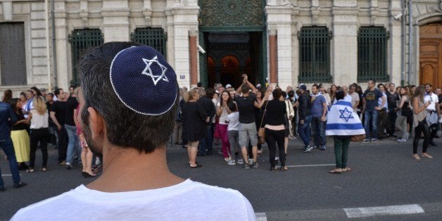 A man wearing a skullcap looks on as people take part in a demonstration called by the Representative Council of Jewish Insti