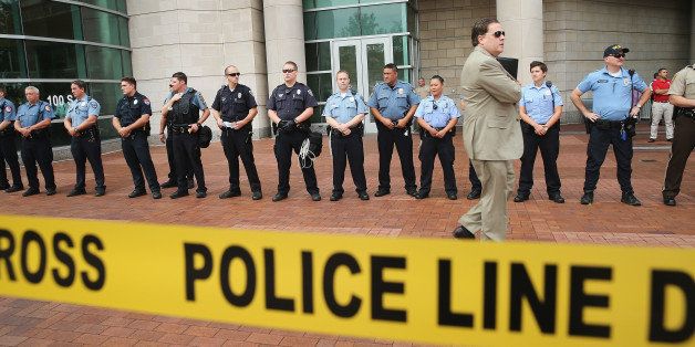 CLAYTON, MO - AUGUST 20: Police guard the front of the Buzz Westfall Justice Center where a grand jury will begin looking at the circumstances surrounding the fatal police shooting of an unarmed teenager Michael Brown on August 20, 2014 in Clayton, Missouri. Brown was shot and killed by a Ferguson, Missouri police officer on August 9. Despite the Brown family's continued call for peaceful demonstrations, violent protests have erupted nearly every night in Ferguson since his death. (Photo by Scott Olson/Getty Images)