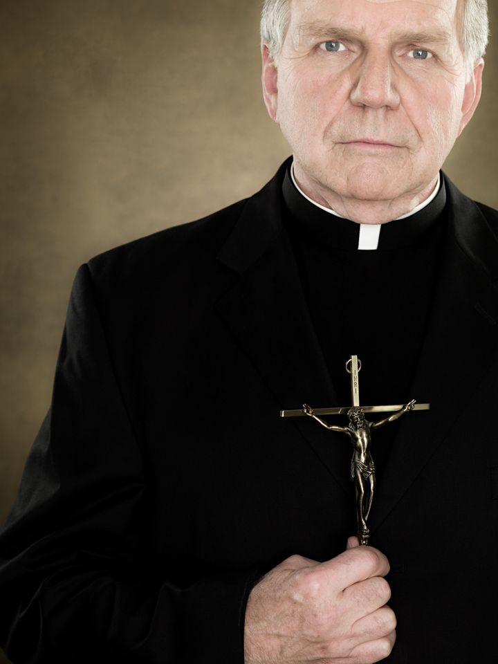A priest holding a crucifix