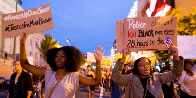 Demonstrators march through the streets in the Chinatown neighborhood of Washington, Saturday, Aug. 23, 2014, during a protes