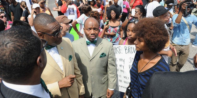 FERGUSON, MO - AUGUST 11: Members of the Nation of Islam speak to protestors during a protest of the shooting death of 18-year-old Michael Brown by a Ferguson police officer, outside Ferguson Police Department Headquarters August 11, 2014 in Ferguson, Missouri. Civil unrest broke out as a result of the shooting of the unarmed black man as crowds looted and burned stores, vandalized vehicles and taunted police officers. Dozens were arrested for various infractions including assault, burglary and theft. (Photo by Michael B. Thomas/Getty Images)