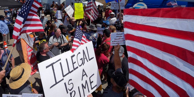 Demonstrators confront each other, Friday, July 4, 2014, outside a U.S. Border Patrol station in Murrieta, Calif. Demonstrators on both sides of the immigration debate had gathered where the agency was foiled earlier this week in an attempt to bus in and process some of the immigrants who have flooded the Texas border with Mexico. (AP Photo/Mark J. Terrill)