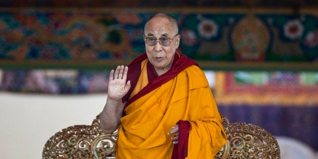 Tibetan spiritual leader the Dalai Lama gestures to devotees before he starts teaching on the fifth day of Kalachakra near Leh, India, Monday, July 7, 2014. Buddhist devotees from across the globe have arrived in this Himalayan region of Ladakh to attend the âKalachakraâ or Wheel of Time initiations by the Dalai Lama that began Thursday. (AP Photo/Tsering Topgyal)