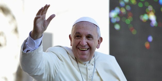Pope Francis salutes the crowd as he arrives for his weekly general audience in St Peter's square at the Vatican on September