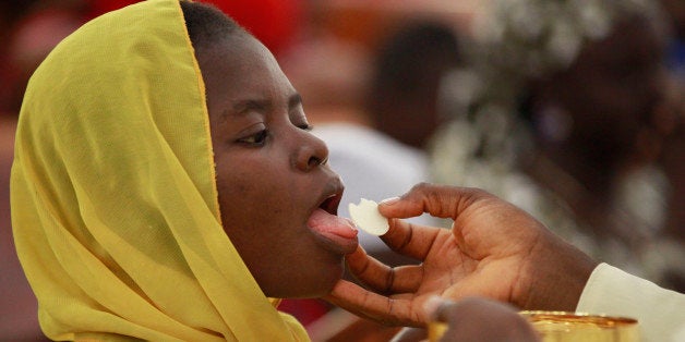 Catholic faithful take Holy Communion and pray for the safety of kidnapped Chibok school girls during a morning Mass given in honour of the schoolgirls, in Abuja, Nigeria, Sunday May 11, 2014. The failure to rescue the kidnapped girl students who remain captive after some four weeks has attracted mounting national and international outrage, and one of the teenagers who escaped from the Islamic extremists who abducted the hundreds of schoolgirls, science student Sarah Lawan said Sunday in an interview with The Associated Press the kidnapping was "too terrifying for words". (AP Photo/Sunday Alamba)