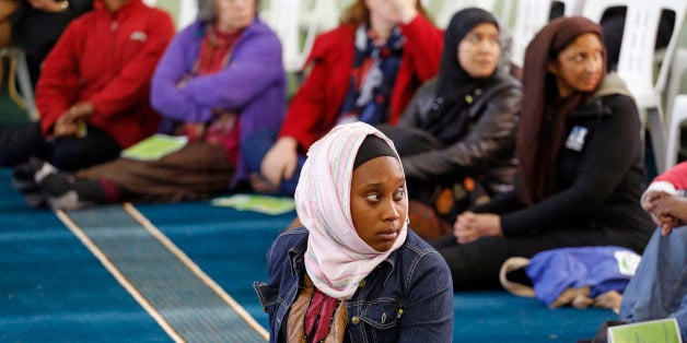 A woman listens inside the Open Mosque, as she and other woman share the same area with men in Cape Town, South Africa, Friday, Sept. 19, 2014. The Open Mosque was founded by Dr. Taj Hargey and is based on gender equality and non-sectarian Islamic rules - Christians and people from other religions are welcomed and woman share the same area for prayers as men inside the mosque. Hargey claims it is the first of its kind in South Africa. (AP Photo/Schalk van Zuydam)