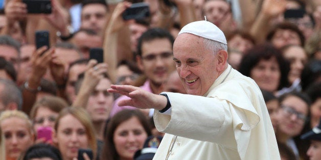 Pope Francis waves to faithful as he is driven through the crowd, in Mother Teresa Square, in Tirana, Sunday, Sept. 21, 2014. Pope Francis arrived Sunday in Albania on his first European trip, designed to highlight the Balkan nation's path from a brutal communist state where religion was banned to a model of Christian-Muslim coexistence for a world witnessing conflict in God's name. (AP Photo/Hector Pustina)