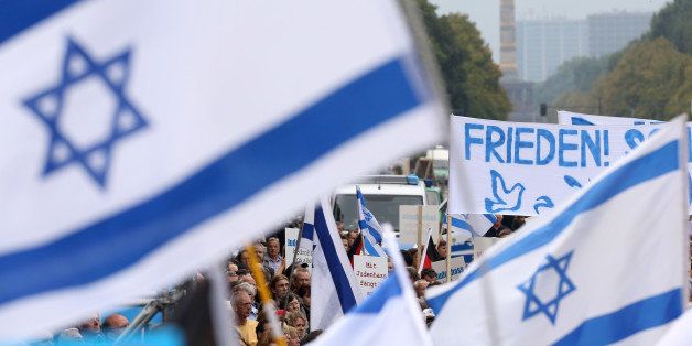 BERLIN, GERMANY - SEPTEMBER 14: Israeli flags and a banner with the word 'Peace' in German fly in front of the Siegesaeule, or Prussian Victory Column, during a rally against anti-Semitism on September 14, 2014 in Berlin, Germany. With the slogan 'Stand Up! Never Again Hatred Towards Jews' ('Steh auf! Nie wieder Judenhass'), the Central Council of Jews in Germany (Zentralrat der Juden) organized the demonstration after anti-Semitic incidents in the country occurring in the wake of the conflict in Gaza this summer, in which more than 2,000 Palestinians were killed by the Israeli government, the majority of whom were civilians, according to Palestinian authorities. (Photo by Adam Berry/Getty Images)
