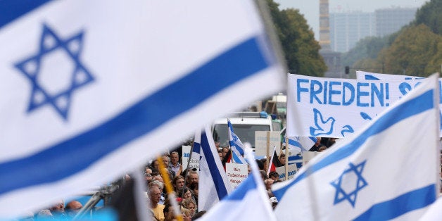 BERLIN, GERMANY - SEPTEMBER 14: Israeli flags and a banner with the word 'Peace' in German fly in front of the Siegesaeule, o